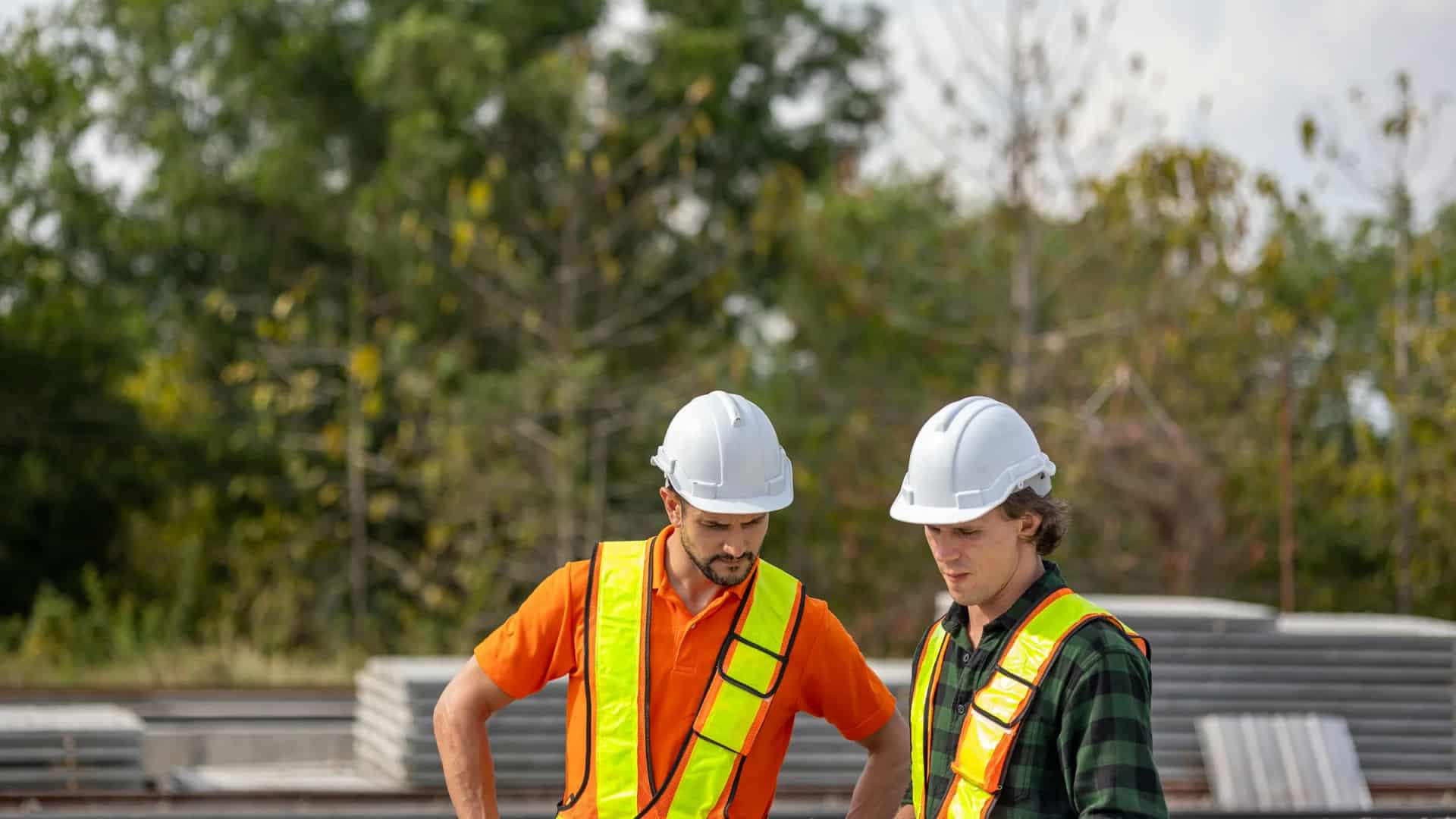 Two construction professionals reviewing project information together at an active worksite.