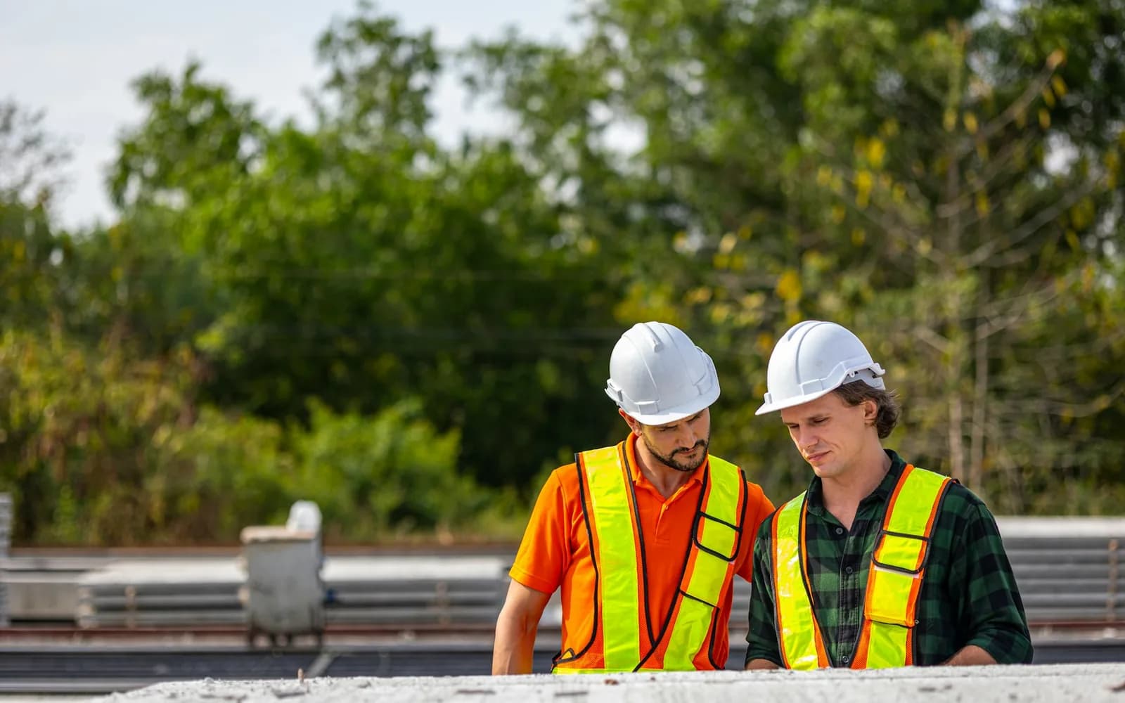 Two construction professionals reviewing project plans together at a worksite.