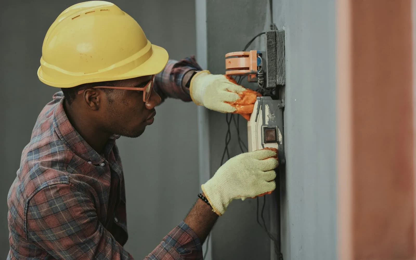 An electrician completing specialty trade work with safety equipment.