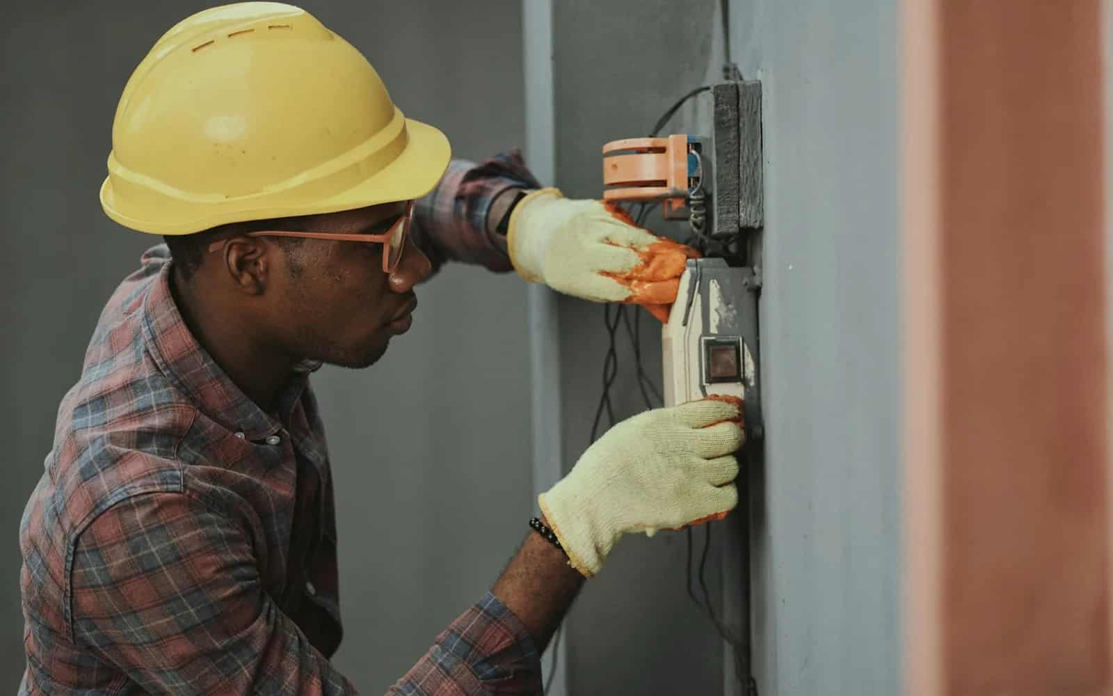An electrician completing specialty trade work with safety equipment.